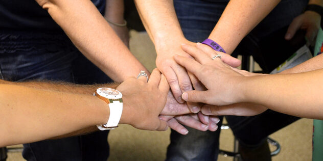 Eine Gruppe legt die Hände in ihrer Mitte aufeinander, Bild: © sheriyates auf pixabay